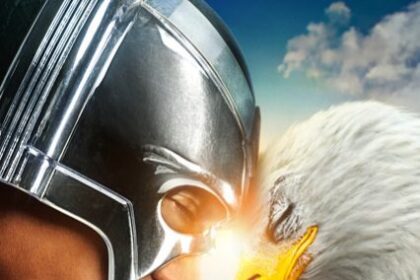 The official Peacemaker Season 2 poster featuring a close-up of Peacemaker's chrome helmeted head facing an American bald eagle (Eagly), nose-to-beak, against a blue sky. The show title 'PEACEMAKER' is prominent.